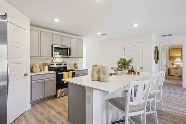 a kitchen with microwave a stove top oven and refrigerator