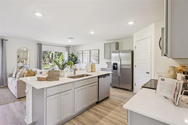 a kitchen with a refrigerator sink and white cabinets