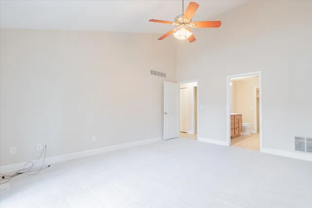 a view of an empty room with a chandelier fan