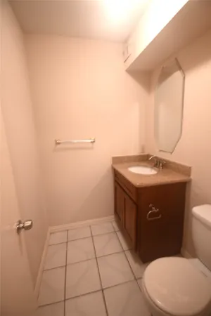 a bathroom with a granite countertop toilet and a sink