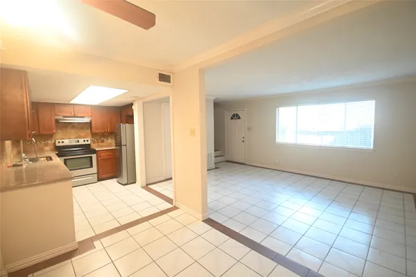 a view of a kitchen with kitchen island granite countertop wooden floor and stainless steel appliances