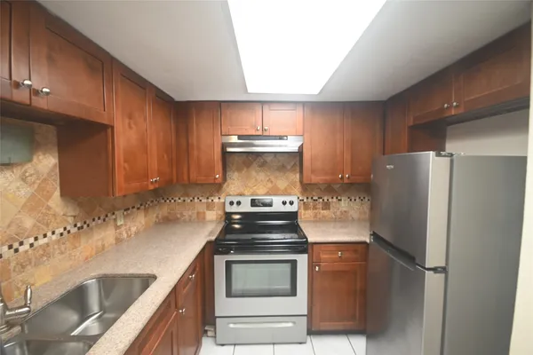 a kitchen with granite countertop a stove and a refrigerator