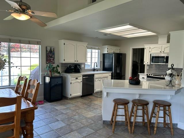 3046 Cypress Avenue Clovis, CA 93611 - Photo 11 of 48 a kitchen with a table chairs microwave and cabinets