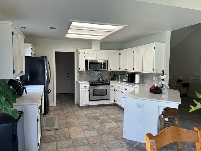 3046 Cypress Avenue Clovis, CA 93611 - Photo 10 of 48 a kitchen with stainless steel appliances a stove a sink a microwave a refrigerator and cabinets