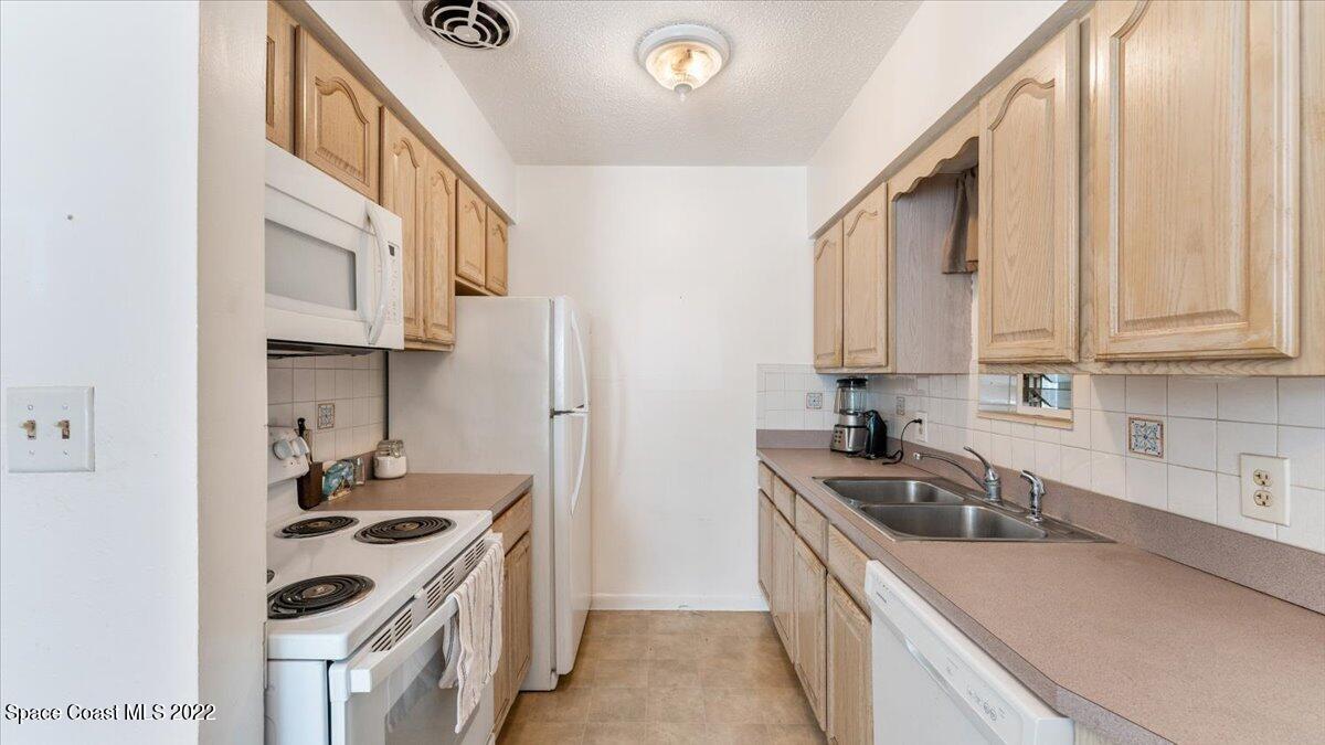 2914 Stetson Street Melbourne, FL 32901 - Photo 11 of 22 a kitchen with stainless steel appliances granite countertop a sink stove and refrigerator