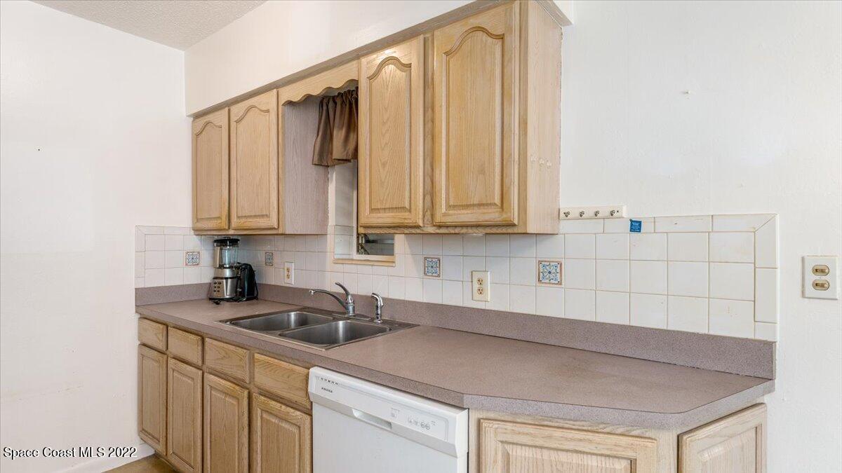 2914 Stetson Street Melbourne, FL 32901 - Photo 10 of 22 a kitchen with stainless steel appliances granite countertop a sink a refrigerator and cabinets