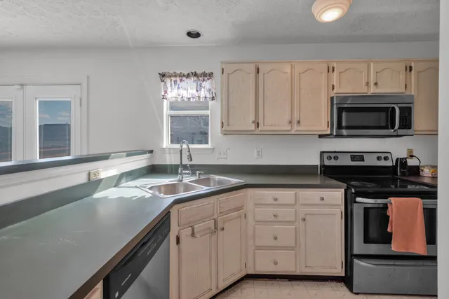a kitchen with appliances a sink and cabinets
