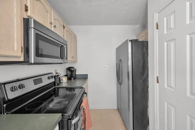 a kitchen with stainless steel appliances granite countertop a stove a refrigerator and a microwave