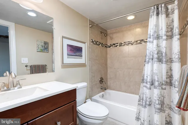 a bathroom with a sink a toilet a mirror a shower and a bathtub