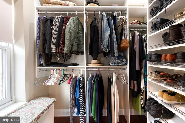 a view of walk in closet with clothes and shoes