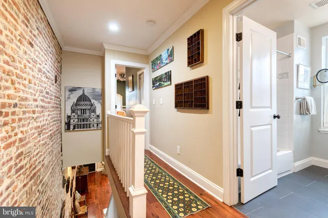 a view of a hallway with wooden floor and staircase