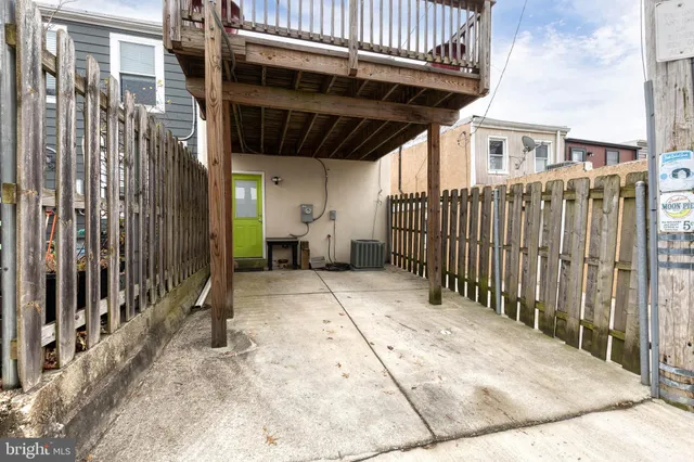 a view of backyard with barbeque grill and wooden fence