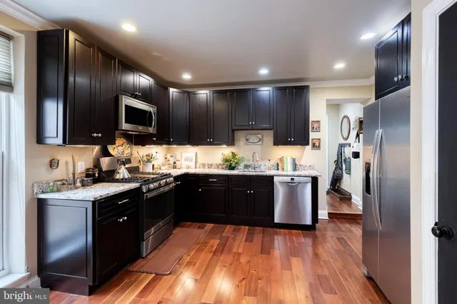 a kitchen with stainless steel appliances granite countertop wooden cabinets a stove top oven a sink and dishwasher