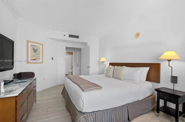 a bedroom with a bed and a lamp on the dresser