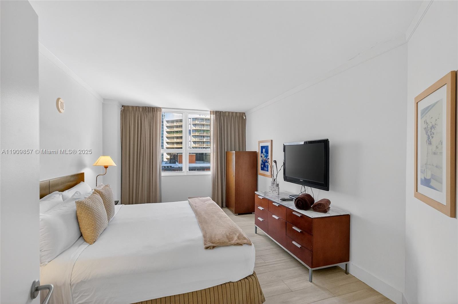 2889 McFarlane Road, Unit 1001 Miami, FL 33133 - Photo 14 of 34 a bedroom with a bed and a flat screen tv