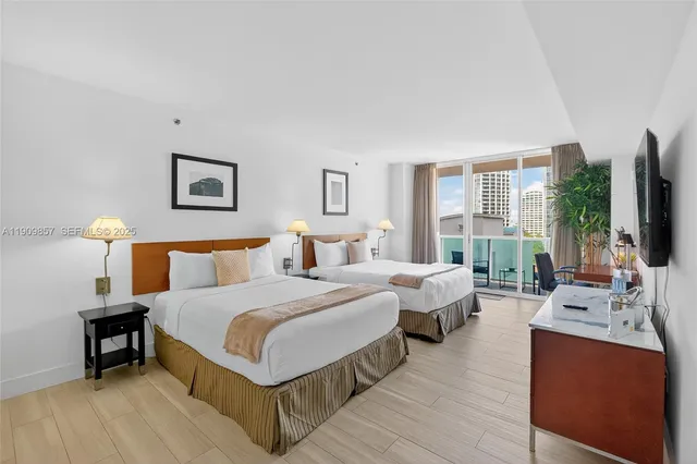 a spacious bedroom with a bed and a flat screen television