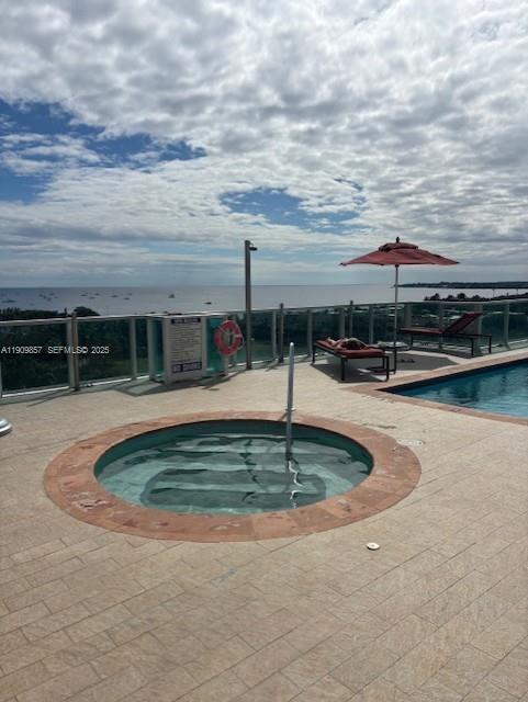 2889 McFarlane Road, Unit 1001 Miami, FL 33133 - Photo 29 of 34 a view of pool with lawn chairs and iron fence