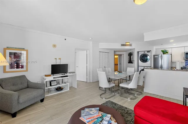 a living room with furniture a flat screen tv and a window