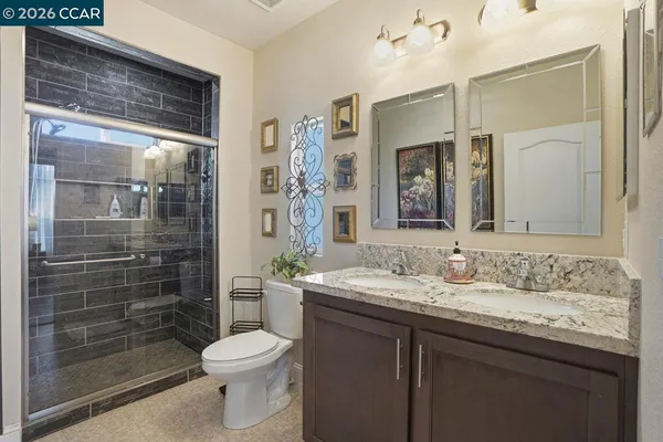a bathroom with a granite countertop sink toilet and shower