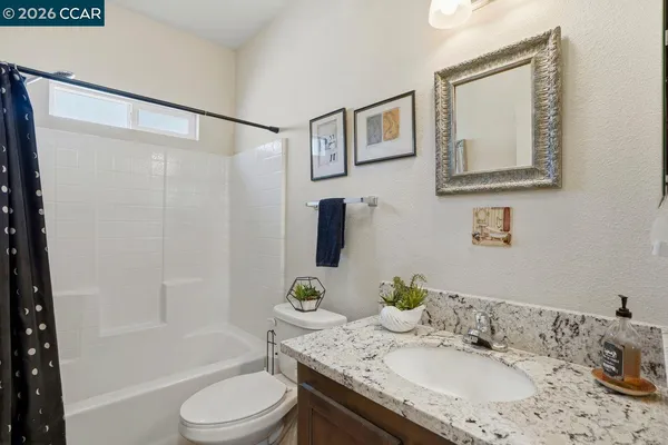 a bathroom with a granite countertop sink toilet and shower