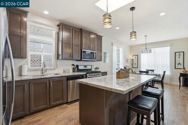 a kitchen with a stove a sink a dining table and chairs
