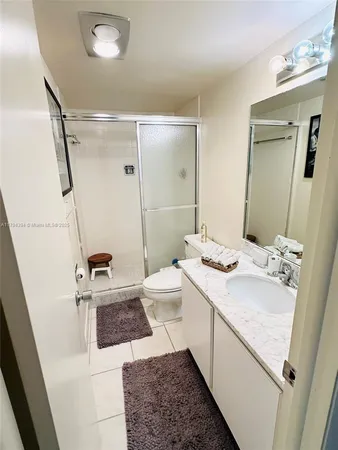 a bathroom with a sink a toilet a mirror and shower