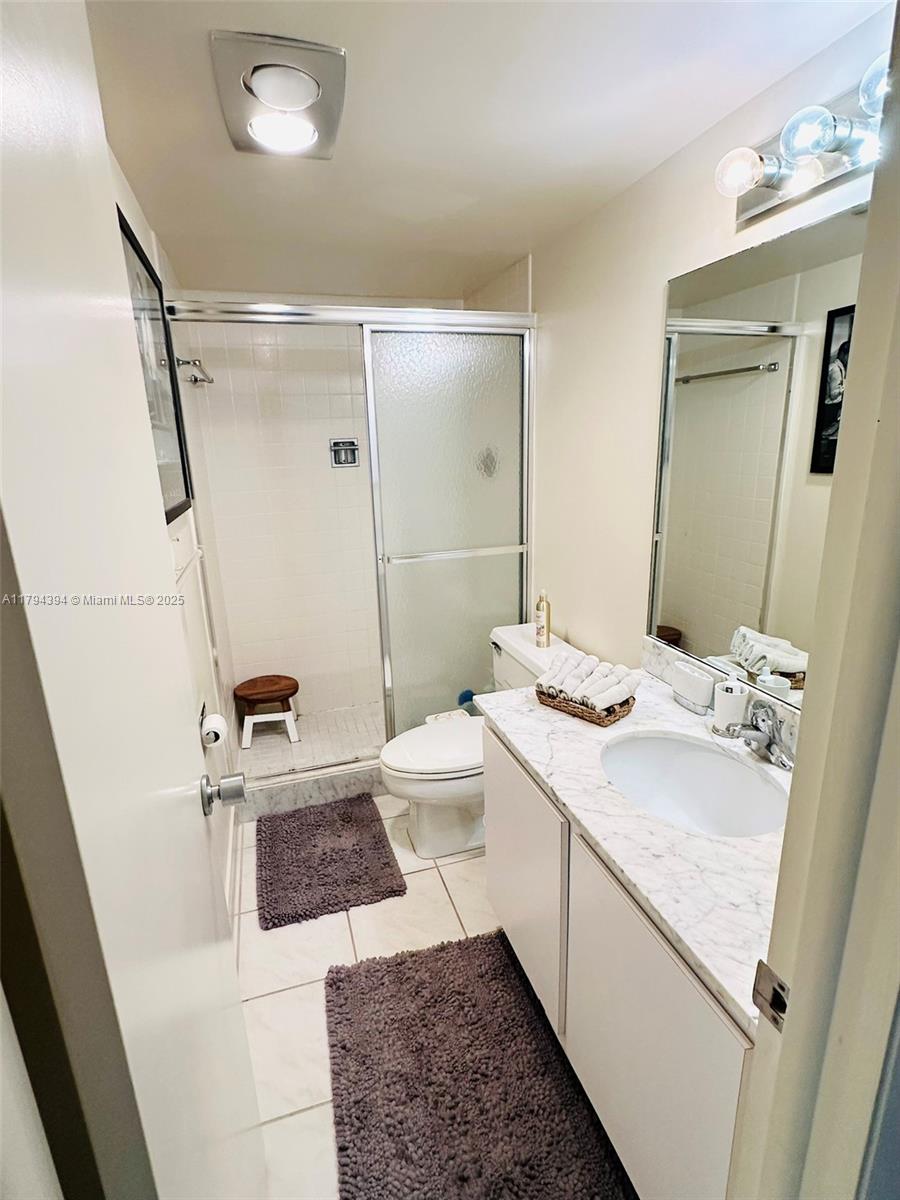 4750 South Ocean Boulevard, Unit 401 Highland Beach, FL 33487 - Photo 13 of 47 a bathroom with a sink a toilet a mirror and shower
