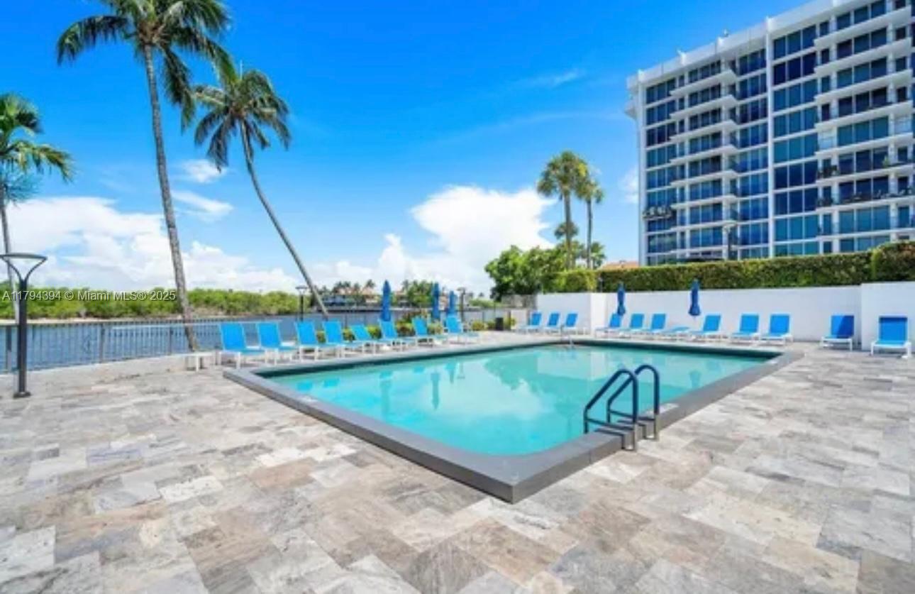 4750 South Ocean Boulevard, Unit 401 Highland Beach, FL 33487 - Photo 42 of 47 a view of a swimming pool with a lawn chairs under an umbrella