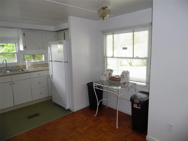 a view of a workspace room with wooden floor and windows