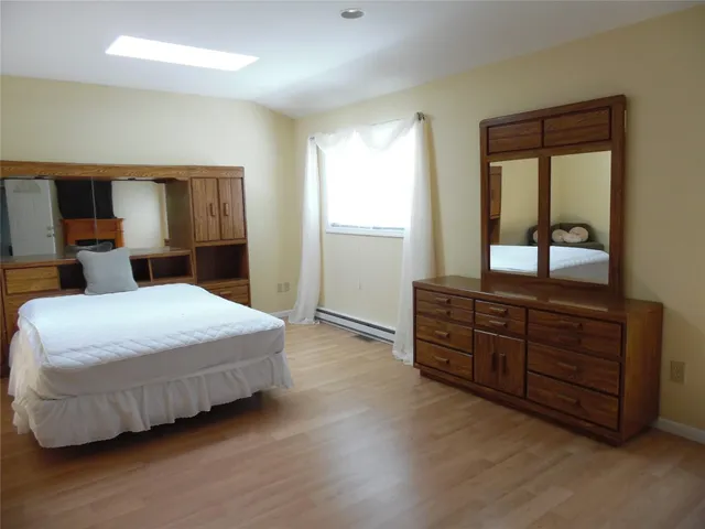 a bedroom with a bed and window with mirror