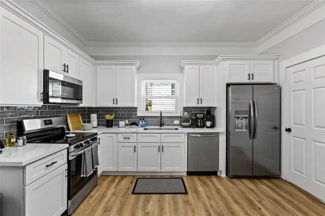 a kitchen with a refrigerator stove top oven and sink