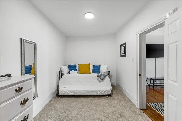 a bedroom with a bed and a flat tv screen in it