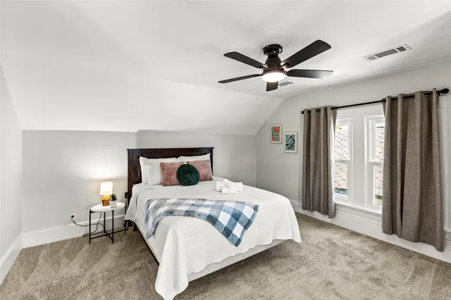 a bedroom with a bed and large windows