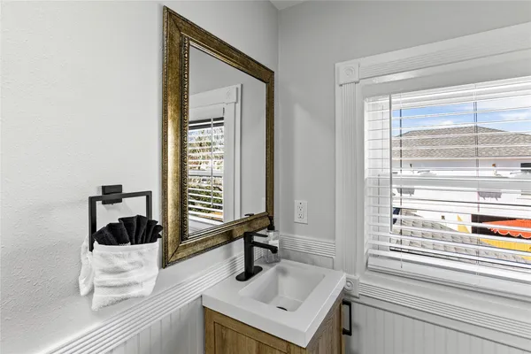 a bathroom with a sink a toilet and a window