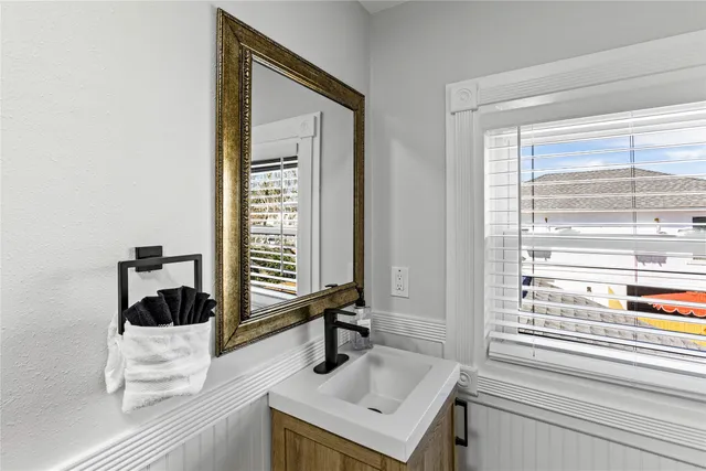 a bathroom with a sink a toilet and a window