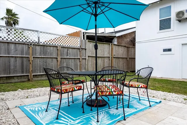 a patio with a table and chairs under an umbrella