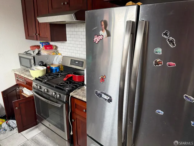 a kitchen with stainless steel appliances granite countertop a refrigerator and a stove