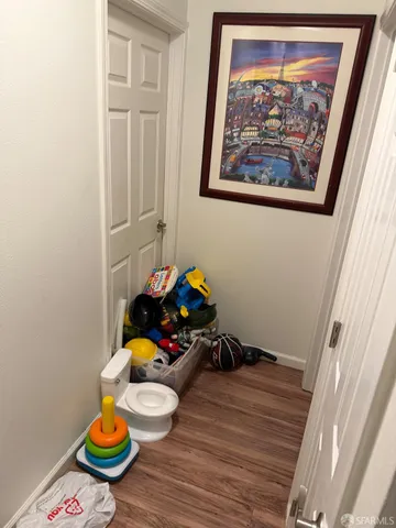 a room with wooden floor and a potted plant