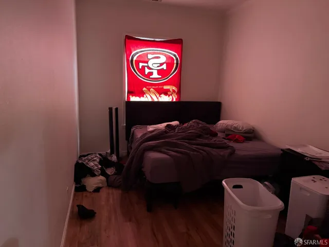 a bedroom with a bed and a a mirror on dresser