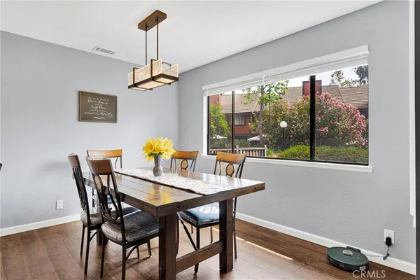 a view of a dining room with furniture a chandelier and wooden floor
