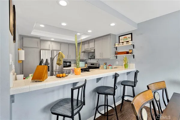 a kitchen with cabinets stainless steel appliances and a counter space