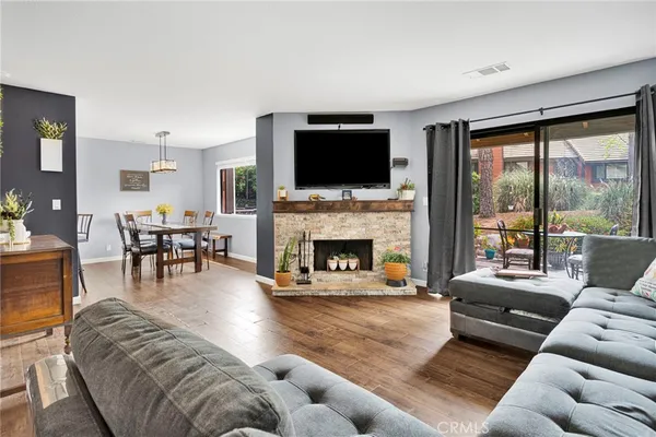 a living room with furniture a potted plant and wooden floor