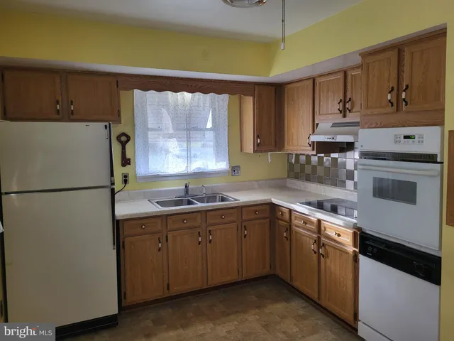 a kitchen with a sink a refrigerator and window