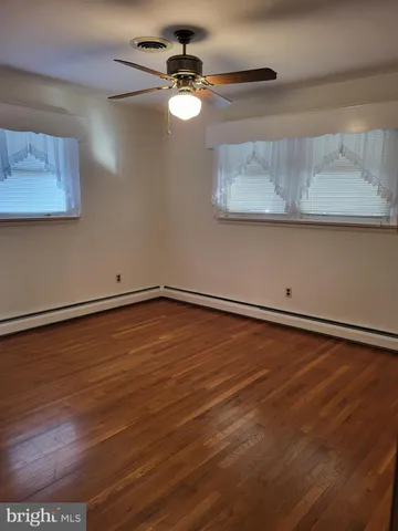 a view of a room with wooden floor and fan