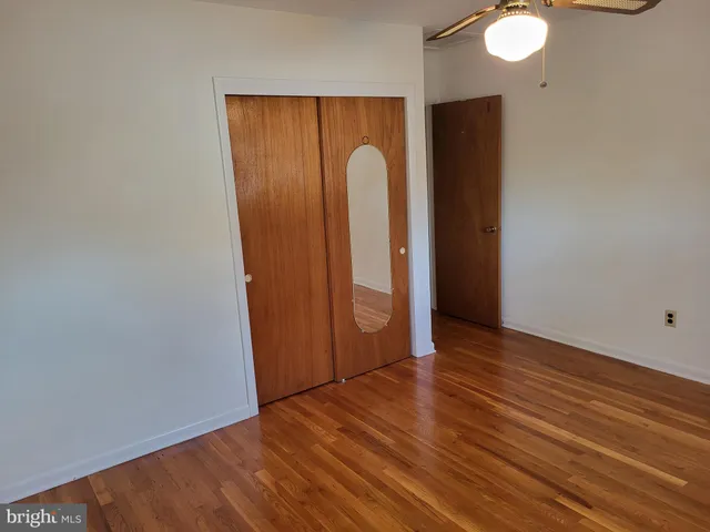 a view of a room with wooden floor and mirror