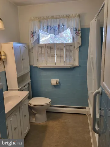 a bathroom with a granite countertop toilet and a sink