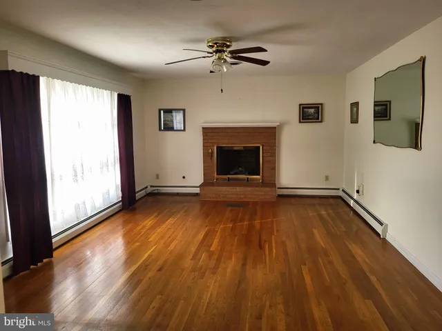 a view of an empty room with a fireplace and a window