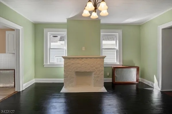 a room with a chandelier and wooden floor