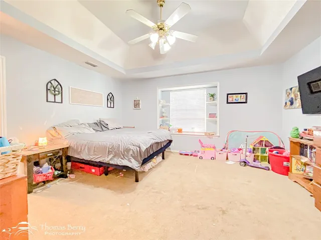 a spacious bedroom with a bed and a chandelier