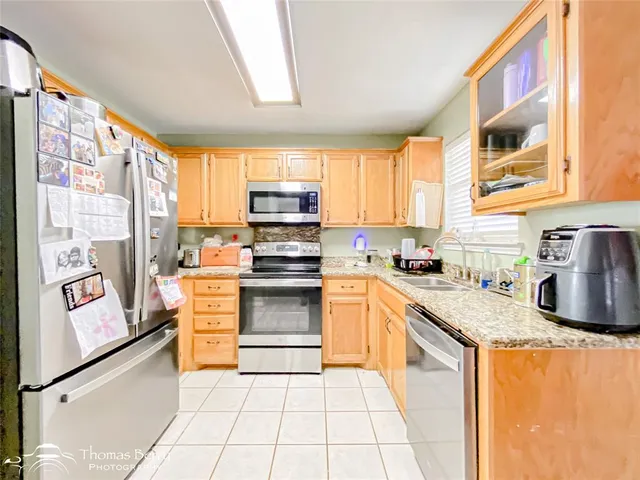 a kitchen with granite countertop a stove a sink and a microwave